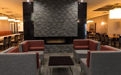 Lobby seating area with a fireplace and contemporary furnishings at Holiday Inn Express Edmonton Downtown, an IHG Hotel.