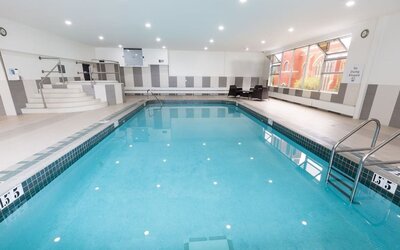 Indoor swimming pool with lounge seating at Holiday Inn Express Edmonton Downtown, an IHG Hotel.