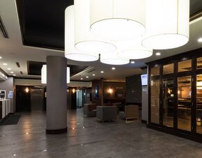 Bright hotel lobby with modern lighting, seating areas, and contemporary design at Holiday Inn Express Edmonton Downtown, an IHG Hotel.