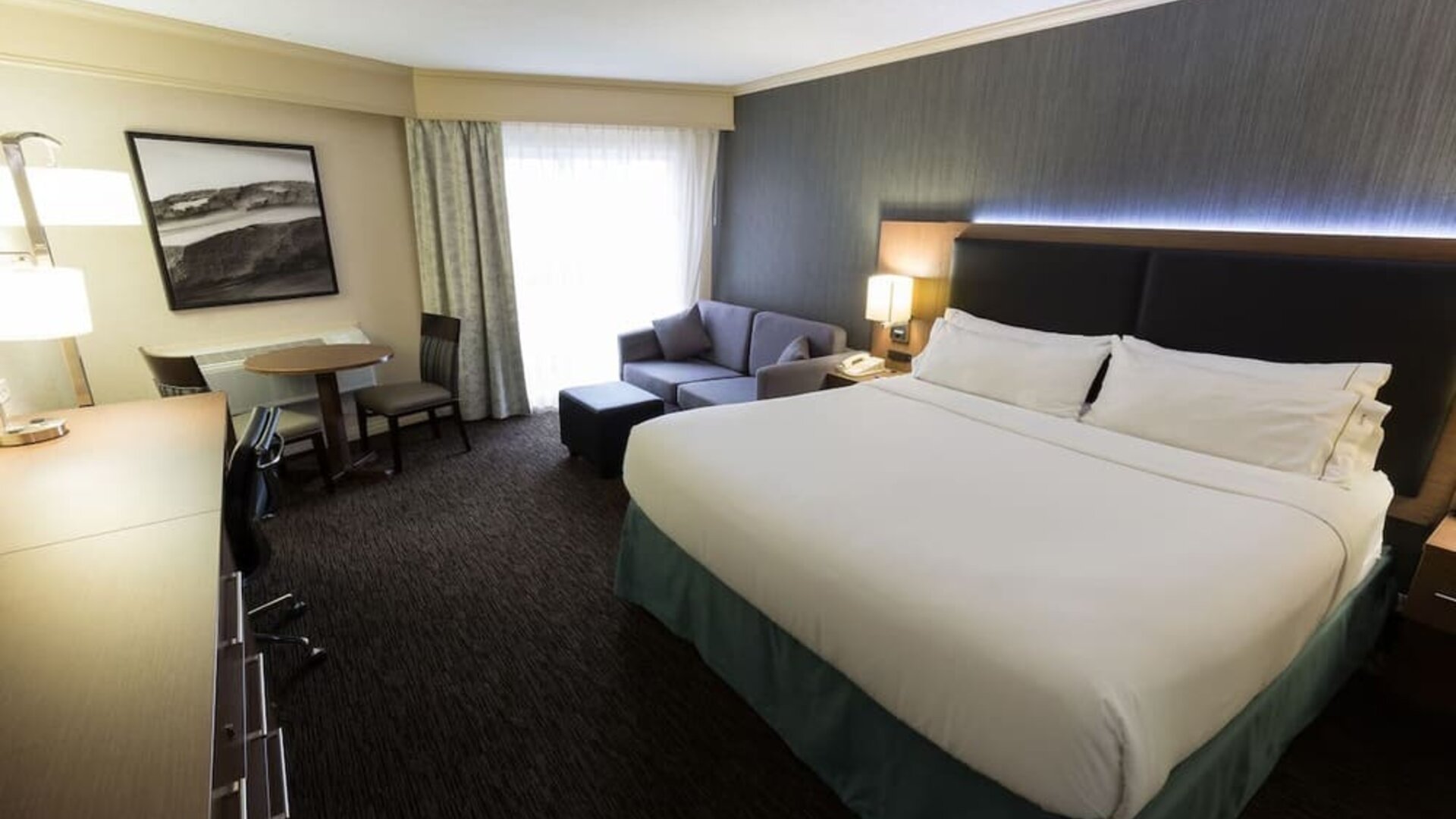 Spacious king guest room featuring a sofa, work desk, and modern amenities at Holiday Inn Express Edmonton Downtown, an IHG Hotel.