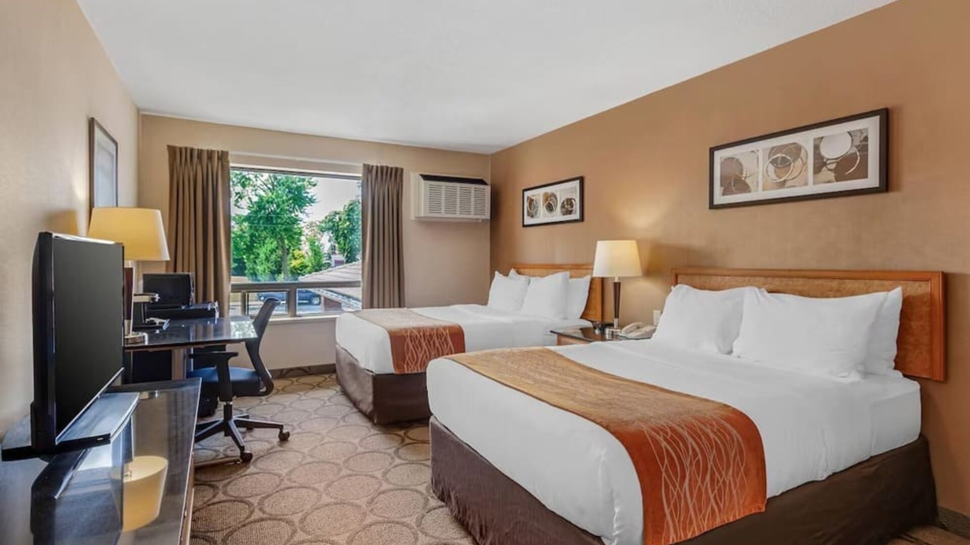 Guest room with two queen beds and a work desk at Comfort Inn Brantford.