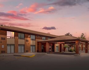 Exterior entrance of Comfort Inn Brantford at sunset.