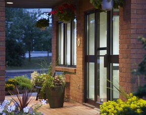 Exterior entrance with landscaped walkway at Comfort Inn Sept-Iles.