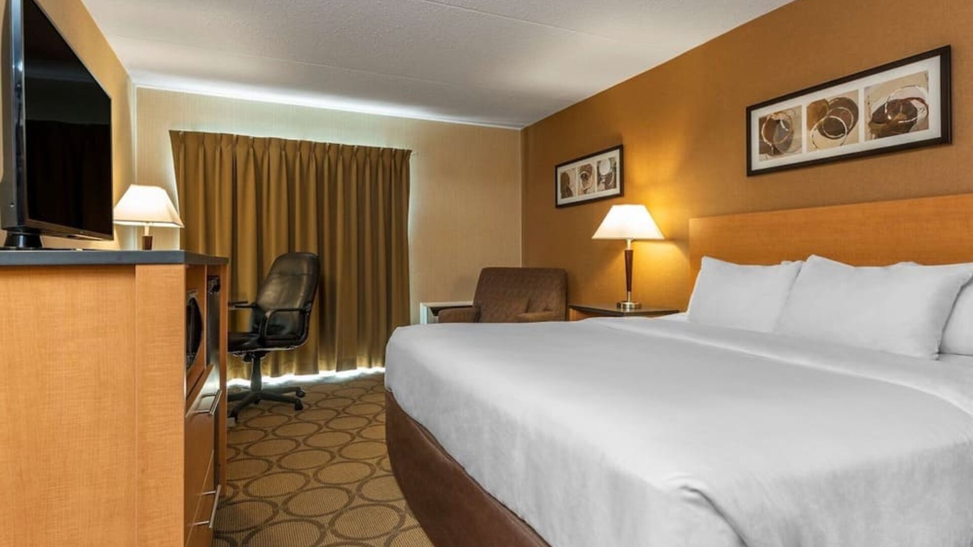 King guest room with a workspace and mini fridge at Comfort Inn Sept-Iles.