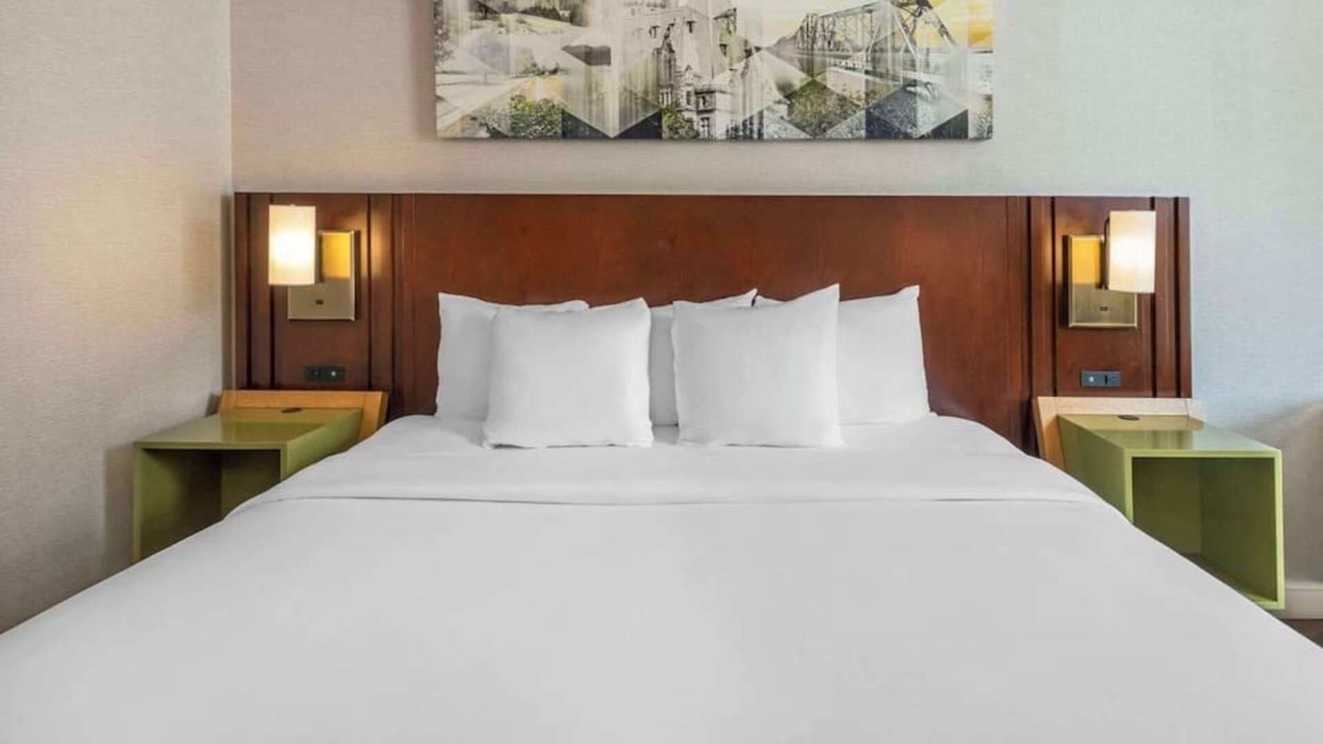 King bed with bedside tables and wall art at Comfort Inn Sault Ste. Marie.