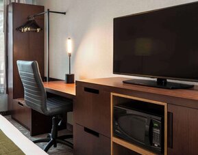 Guest room workspace with a desk, TV, and microwave at Comfort Inn Sault Ste. Marie.