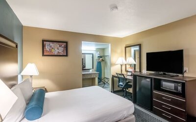 Guest room with a king bed, work desk, TV, microwave, and mini fridge at Glenridge Inn Glendale Pasadena.