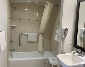 Accessible guest bathroom with a bathtub and shower at Glenridge Inn Glendale Pasadena.