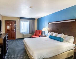 Spacious guest room with a king bed and seating area at Glenridge Inn Glendale Pasadena.