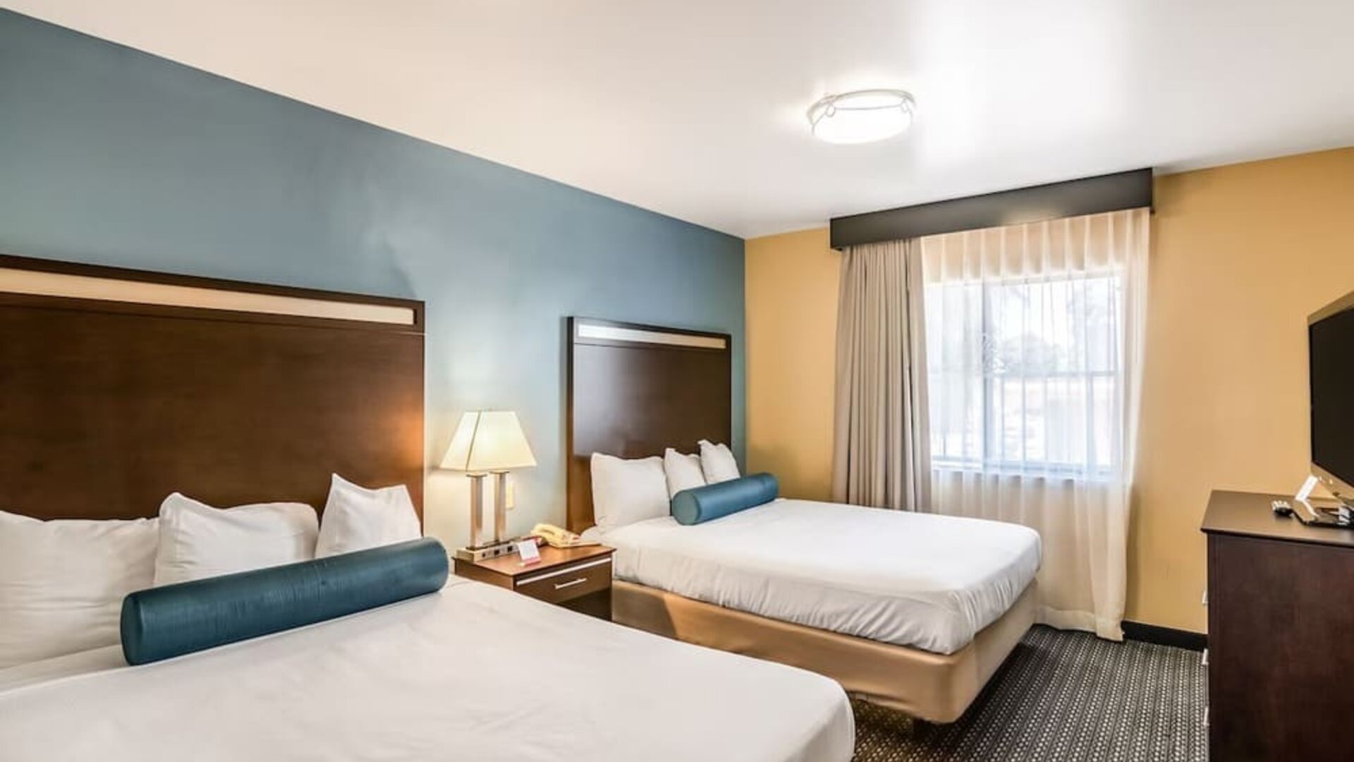 Guest room with two queen beds and a TV at Glenridge Inn Glendale Pasadena.