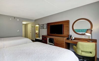 Guest room with two queen beds, work desk, TV, microwave, and mini fridge at Hampton Inn & Suites By Hilton Guelph.
