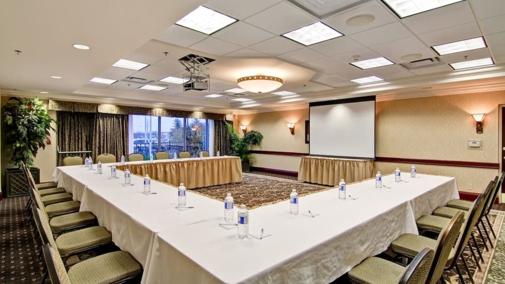 Conference room with U-shaped seating and presentation screen at Hampton Inn & Suites By Hilton Guelph.