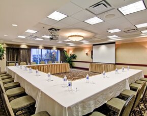 Conference room with U-shaped seating and presentation screen at Hampton Inn & Suites By Hilton Guelph.