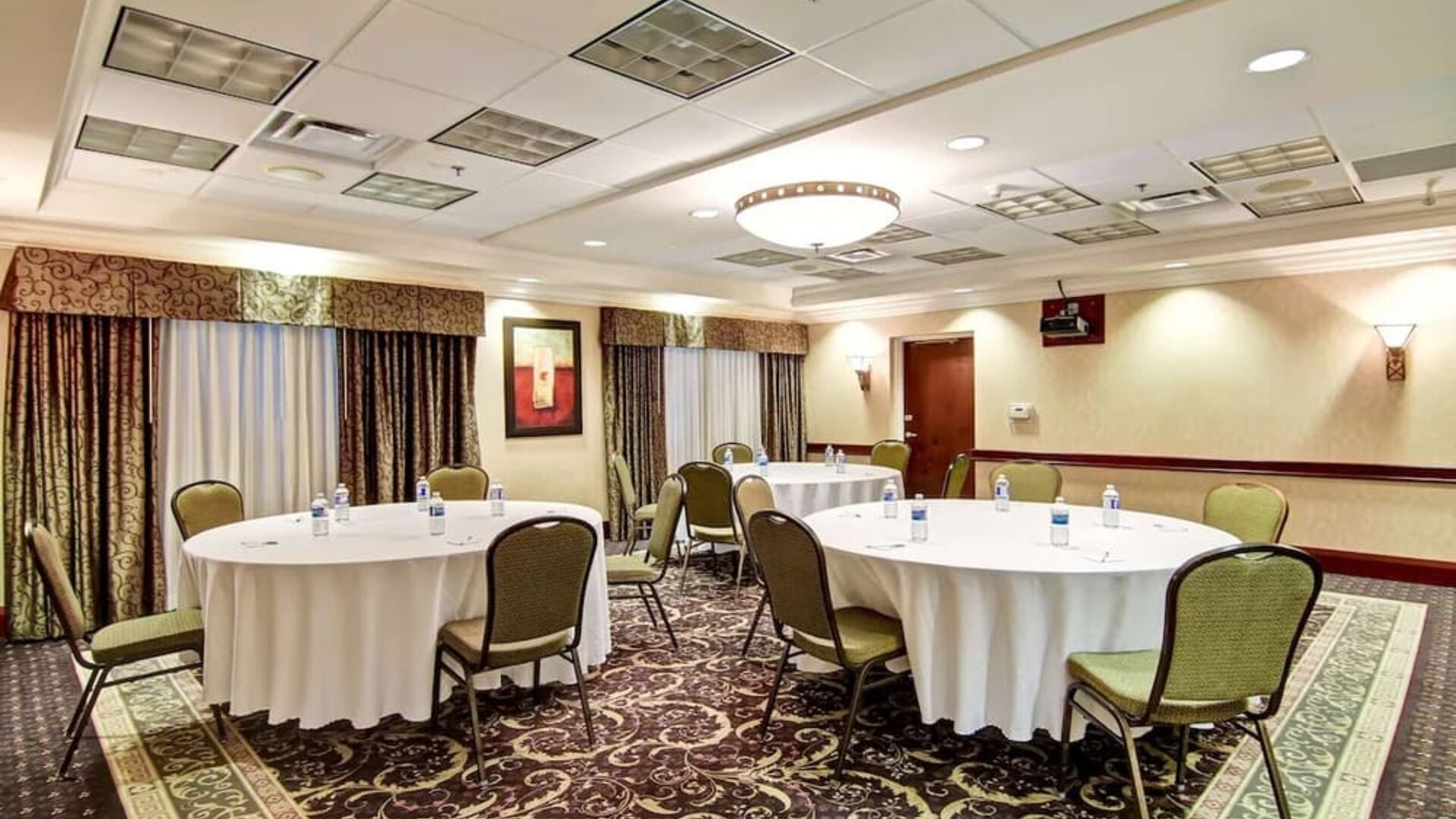 Meeting room with round table seating at Hampton Inn & Suites By Hilton Guelph.