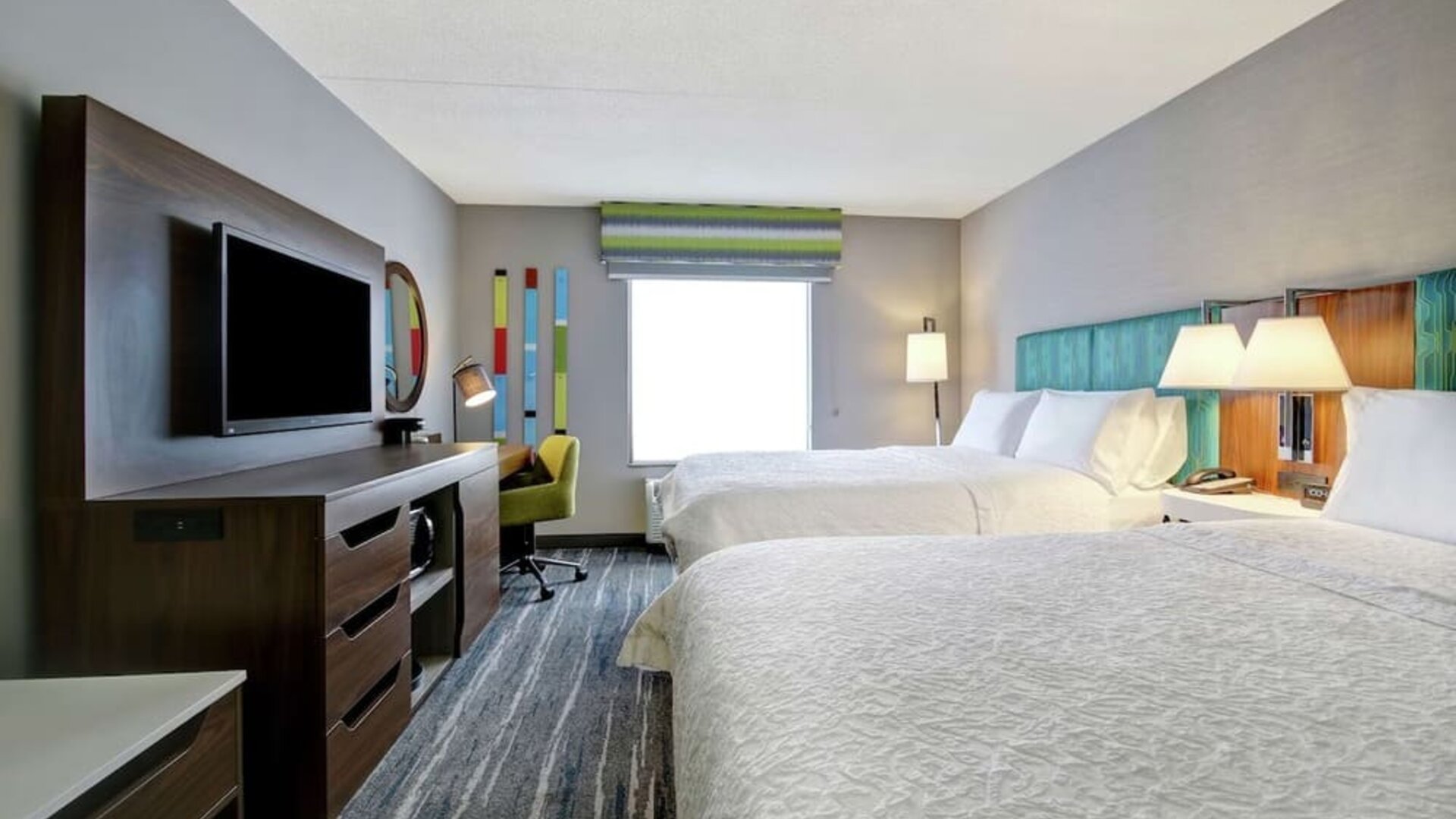 Guest room with two queen beds and modern furnishings at Hampton Inn & Suites By Hilton Guelph.