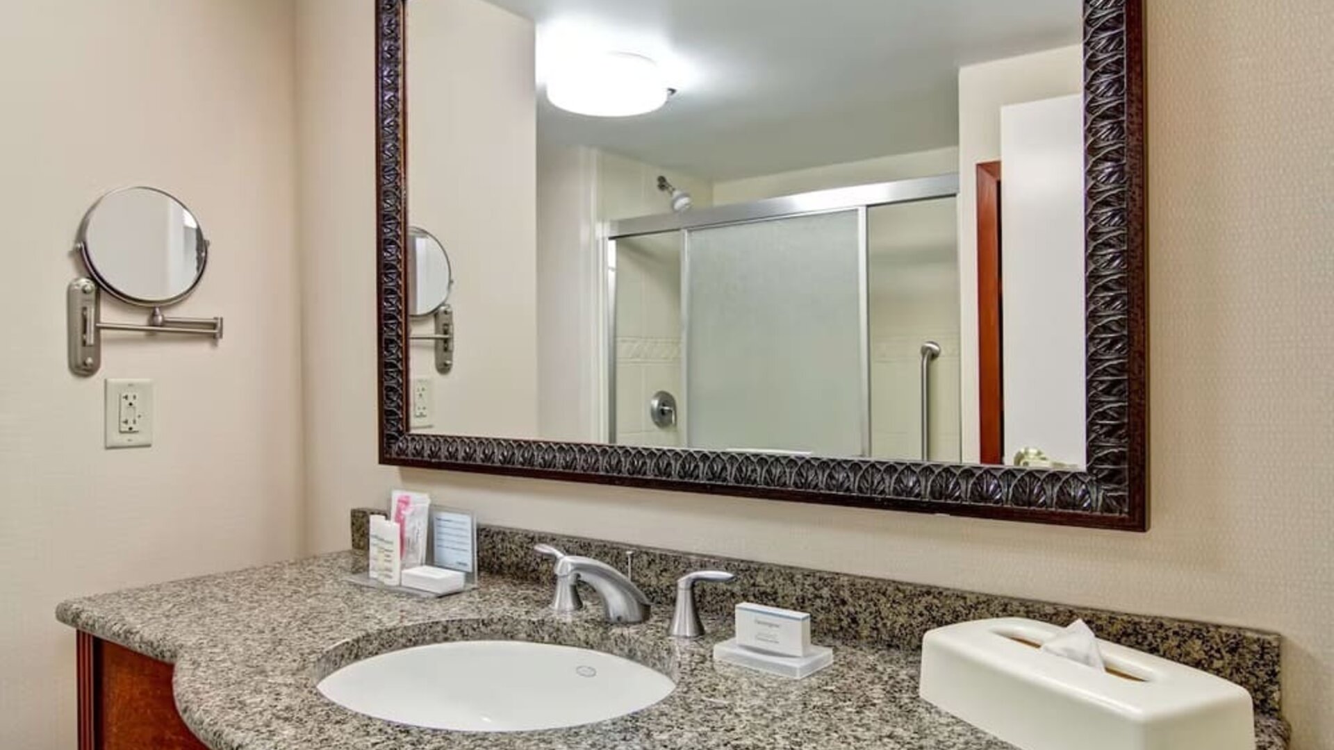 Guest bathroom with a granite vanity and walk-in shower at Hampton Inn & Suites By Hilton Guelph.
