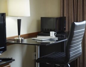 In-room workspace with a desk, microwave, and mini fridge at Comfort Inn Regina.