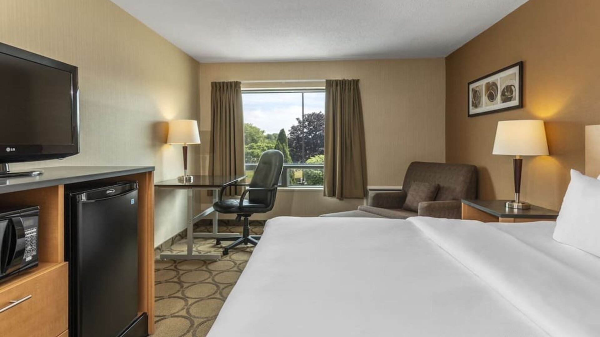 Guest room with a king bed, workspace, and seating area at Comfort Inn Regina.