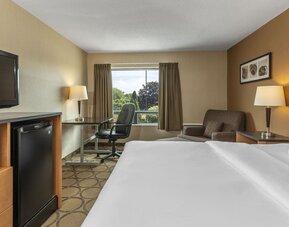 Guest room with a king bed, workspace, and seating area at Comfort Inn Regina.