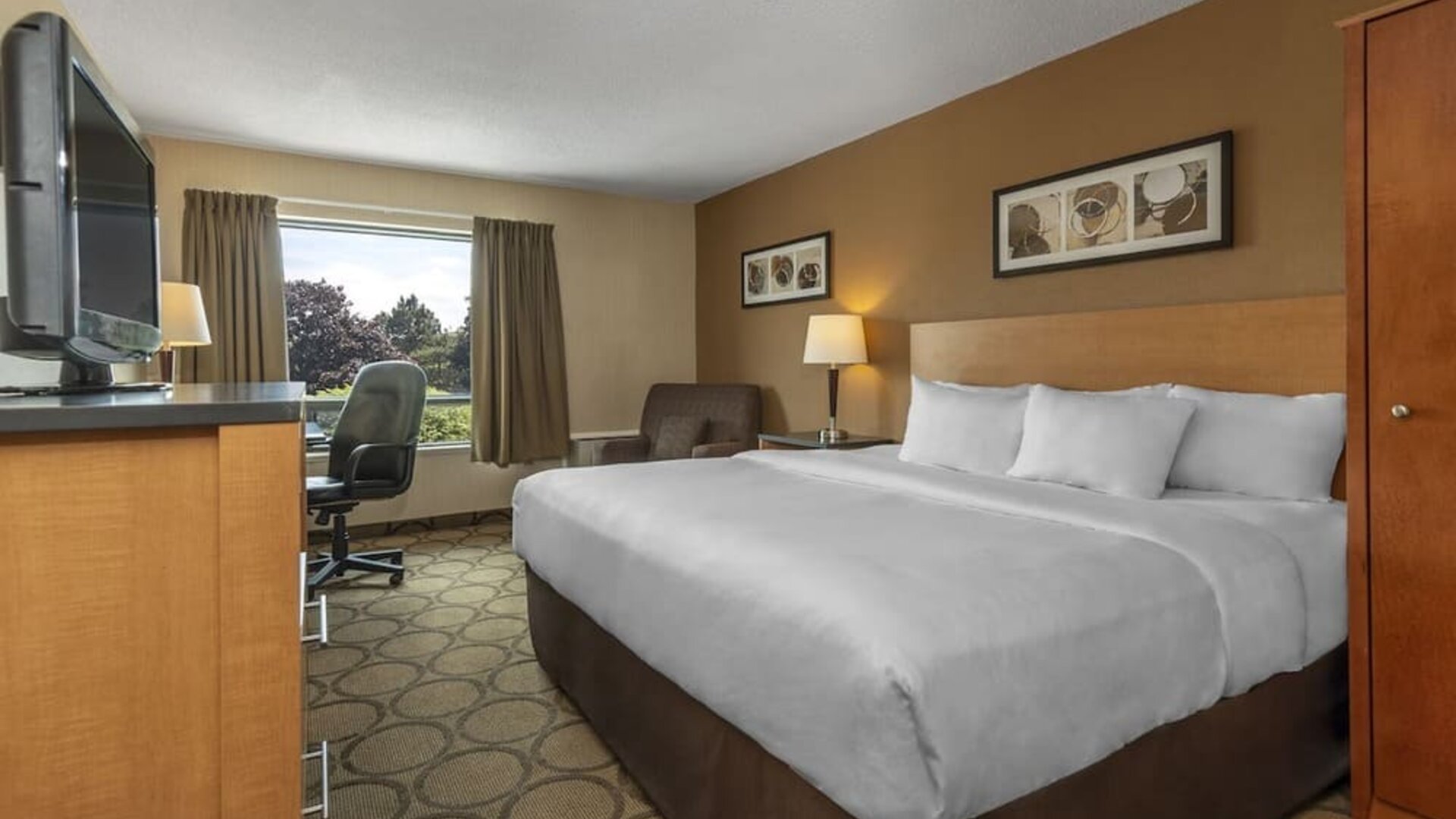 Spacious guest room with a king bed and seating area at Comfort Inn Regina.