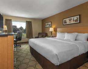 Spacious guest room with a king bed and seating area at Comfort Inn Regina.