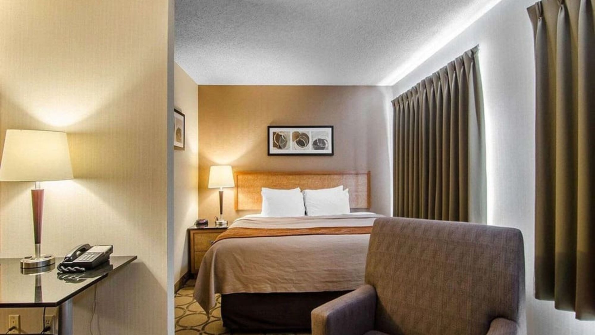 Guest room with a king bed, sofa, and workspace at Comfort Inn Regina.