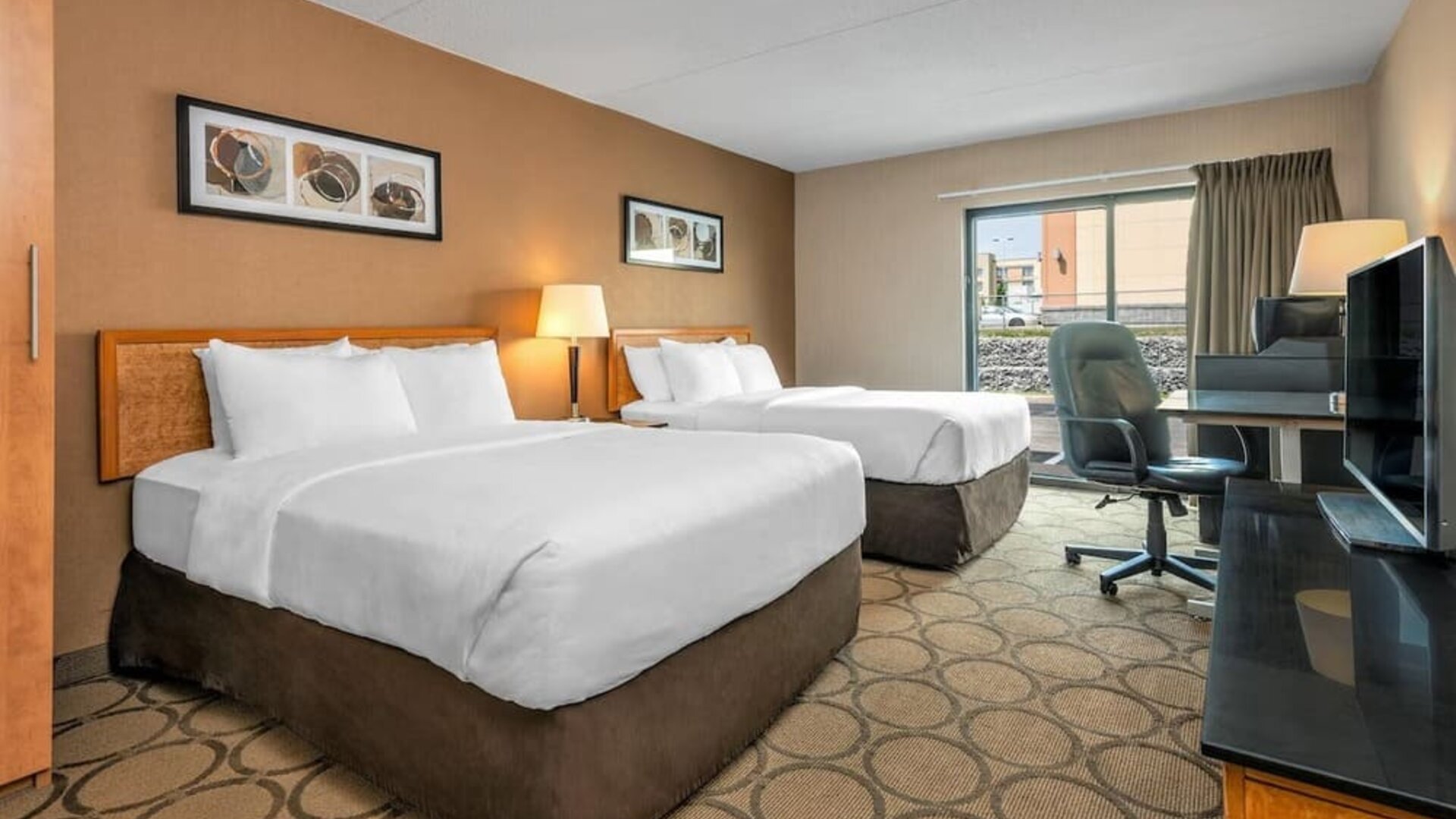 Guest room with two queen beds and a work desk at Comfort Inn Regina.