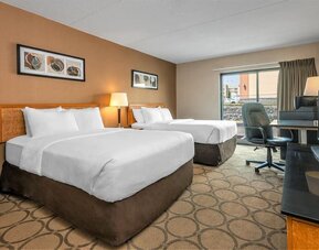 Guest room with two queen beds and a work desk at Comfort Inn Regina.