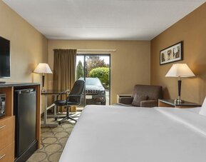 Guest room with a king bed, work desk, and armchair at Comfort Inn Brandon.