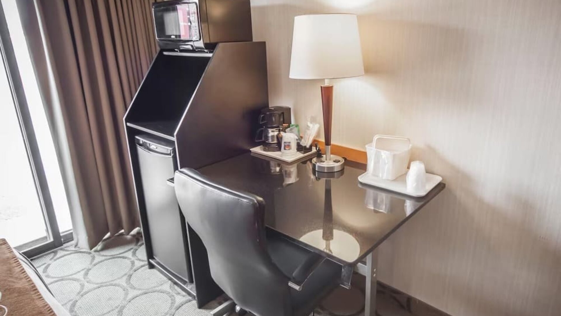 In-room workspace with a desk, coffee station, and mini fridge at Comfort Inn Brandon.