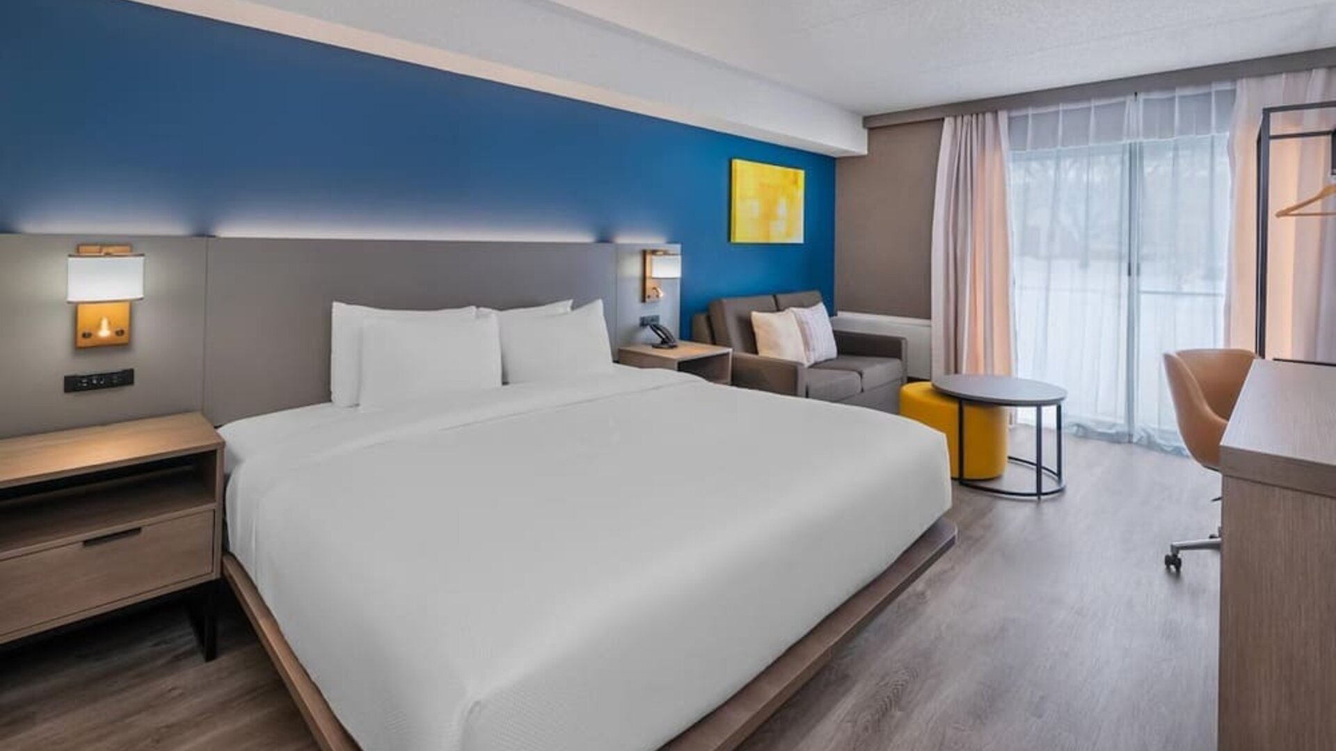 Guest room with a king bed, sofa, and workspace at Comfort Inn Belleville.