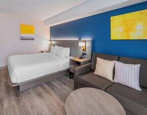 Guest room with a king bed, sofa, and seating area at Comfort Inn Belleville.