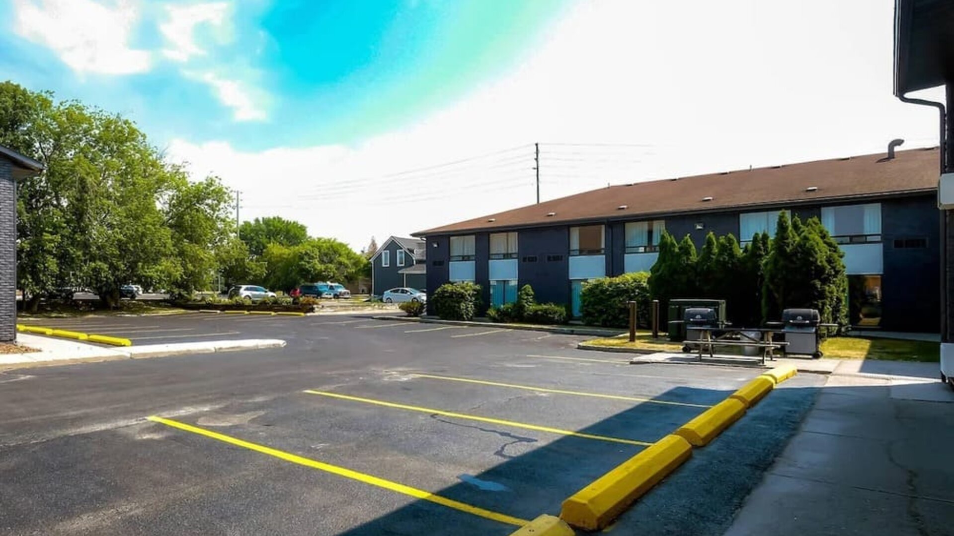 Hotel parking area with outdoor barbecue grills at Comfort Inn Belleville.