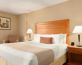 Guest room with a king bed and bedside lighting at Days Inn Edmonton Downtown.