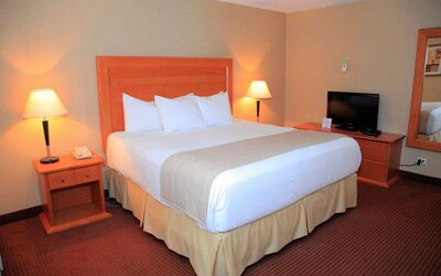 Guest room with a king bed, TV, and bedside tables at Days Inn Edmonton Downtown.