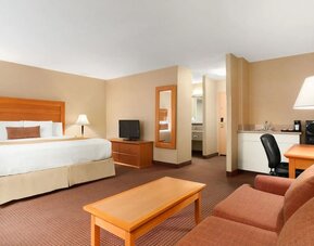 Spacious guest room with a king bed, seating area, and work desk at Days Inn Edmonton Downtown.