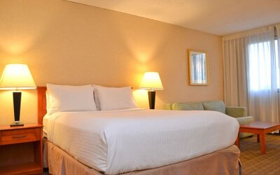 Spacious guest room with a king bed, sofa, and seating area at Amenida Residences.