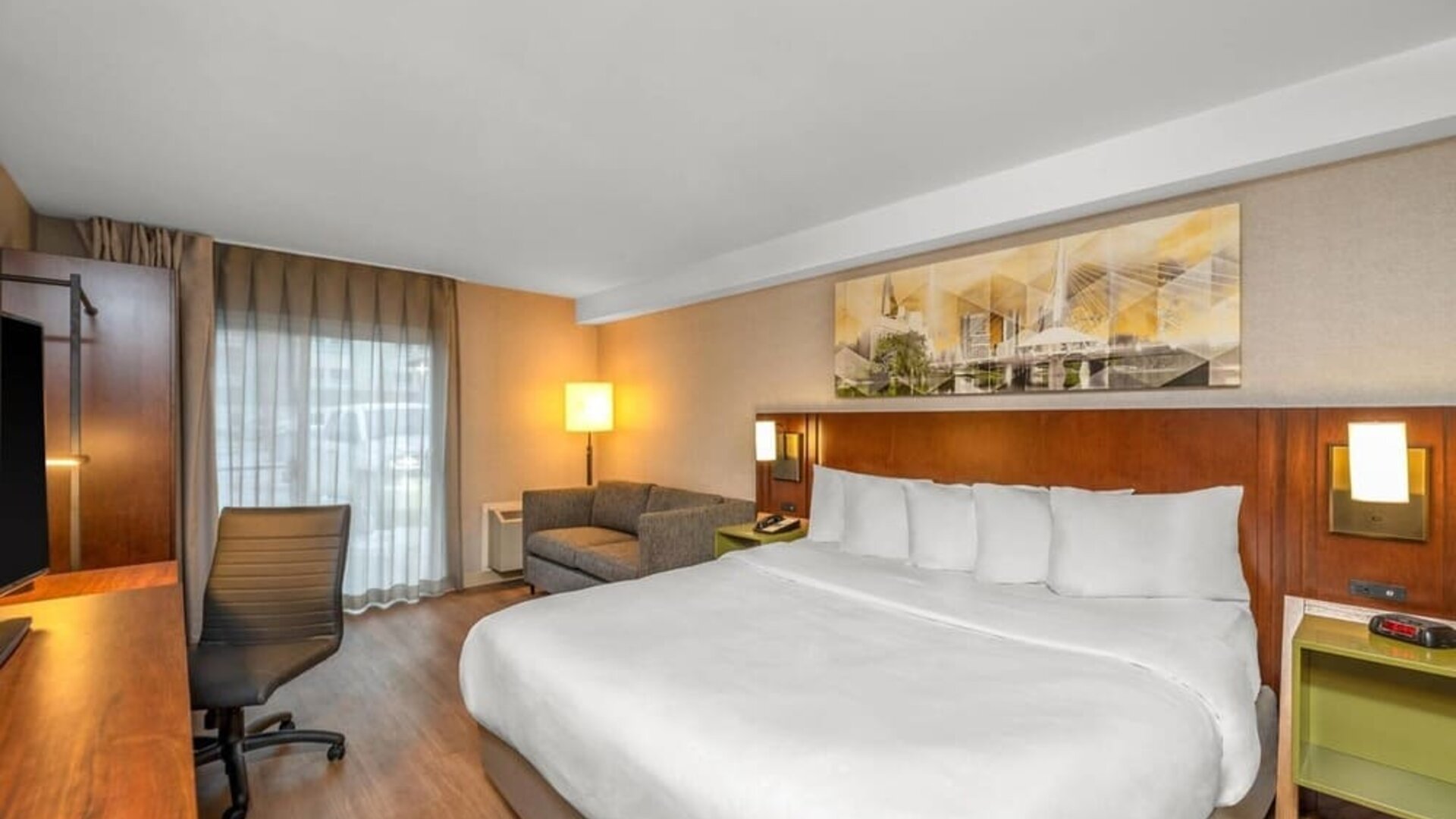 King guest room with a sofa, work desk, and natural light at Comfort Inn Winnipeg Airport.