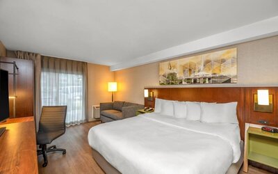 King guest room with a sofa, work desk, and natural light at Comfort Inn Winnipeg Airport.