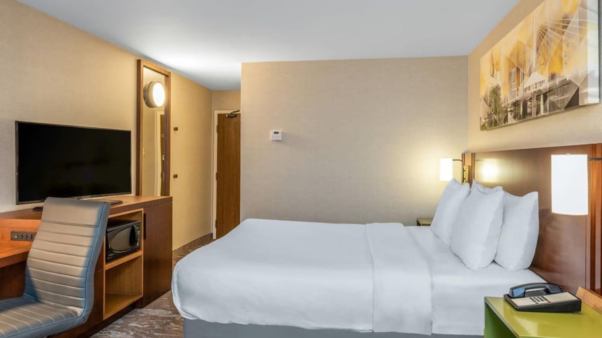 Guest room with a queen bed and workspace at Comfort Inn Winnipeg Airport.