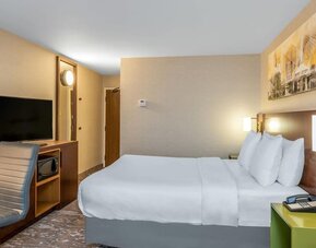 Guest room with a queen bed and workspace at Comfort Inn Winnipeg Airport.