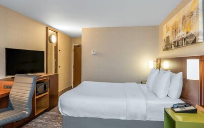 Guest room with a queen bed and workspace at Comfort Inn Winnipeg Airport.