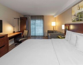 King guest room with a sofa and work desk at Comfort Inn Brossard.
