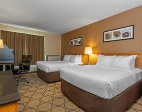 Spacious guest room with two queen beds and a work desk at Comfort Inn Edmonton West.