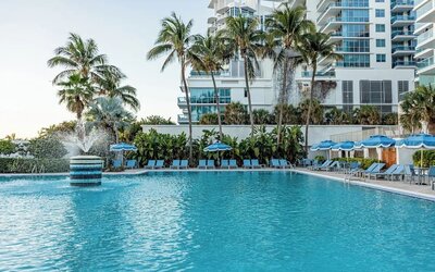 Outdoor swimming pool with palm trees at Sherry Frontenac Oceanfront Hotel.