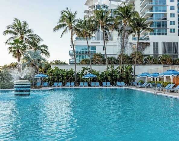 Outdoor swimming pool with palm trees at Sherry Frontenac Oceanfront Hotel.