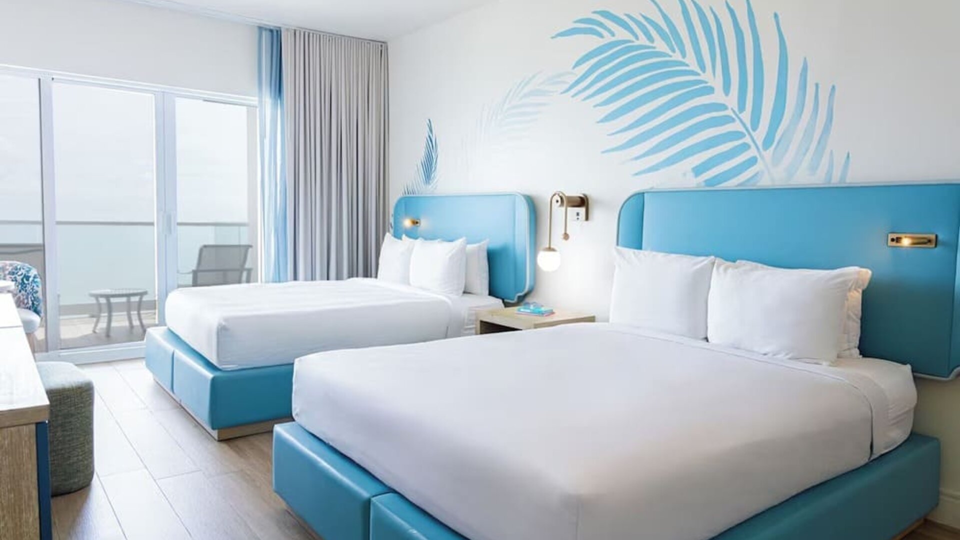 Guest room with two queen beds and a private balcony at Sherry Frontenac Oceanfront Hotel.