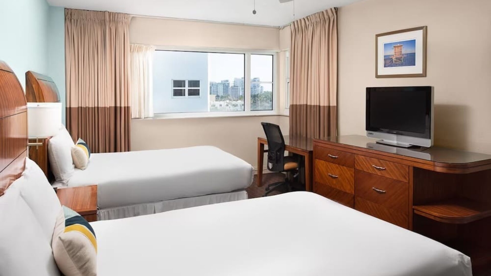 Guest room with two queen beds and tropical décor at Sherry Frontenac Oceanfront Hotel.