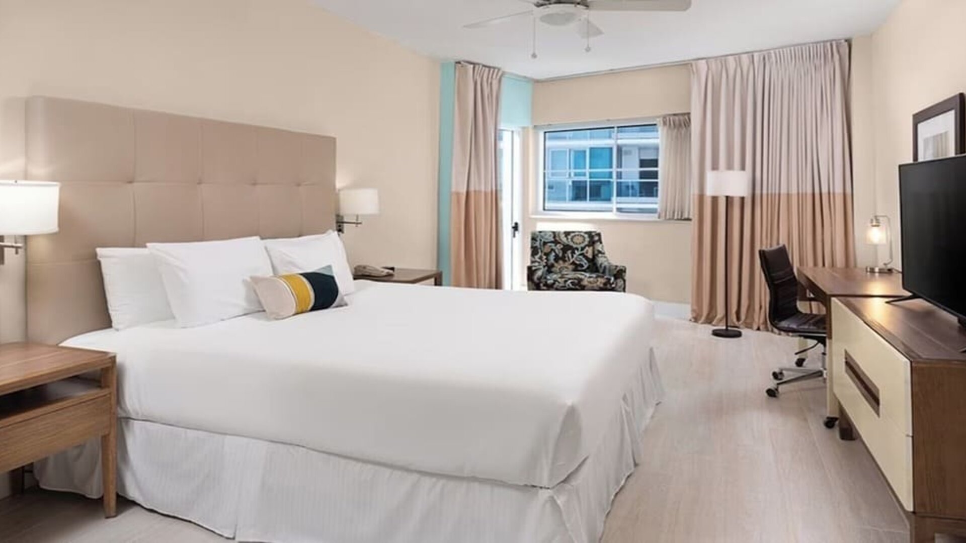 Spacious guest room with a king bed and work desk at Sherry Frontenac Oceanfront Hotel.