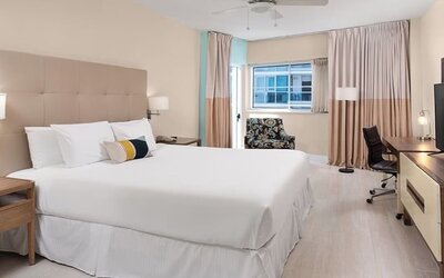 Spacious guest room with a king bed and work desk at Sherry Frontenac Oceanfront Hotel.